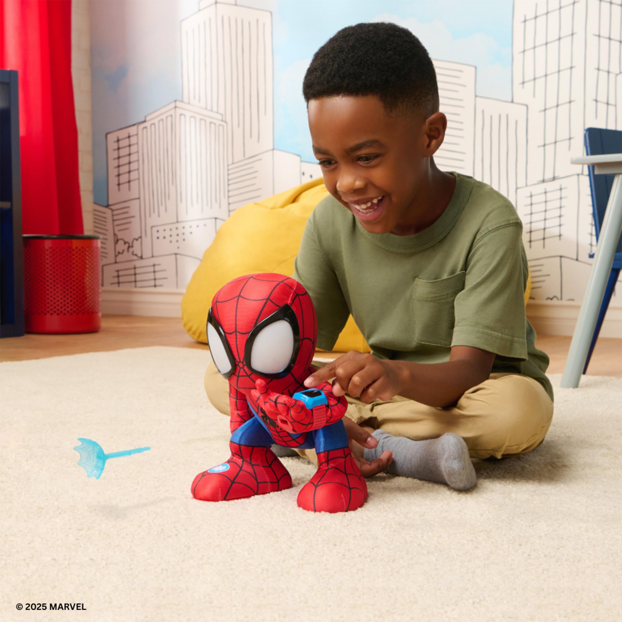 Child playing with a Spider-Man toy in a room with cityscape wallpaper